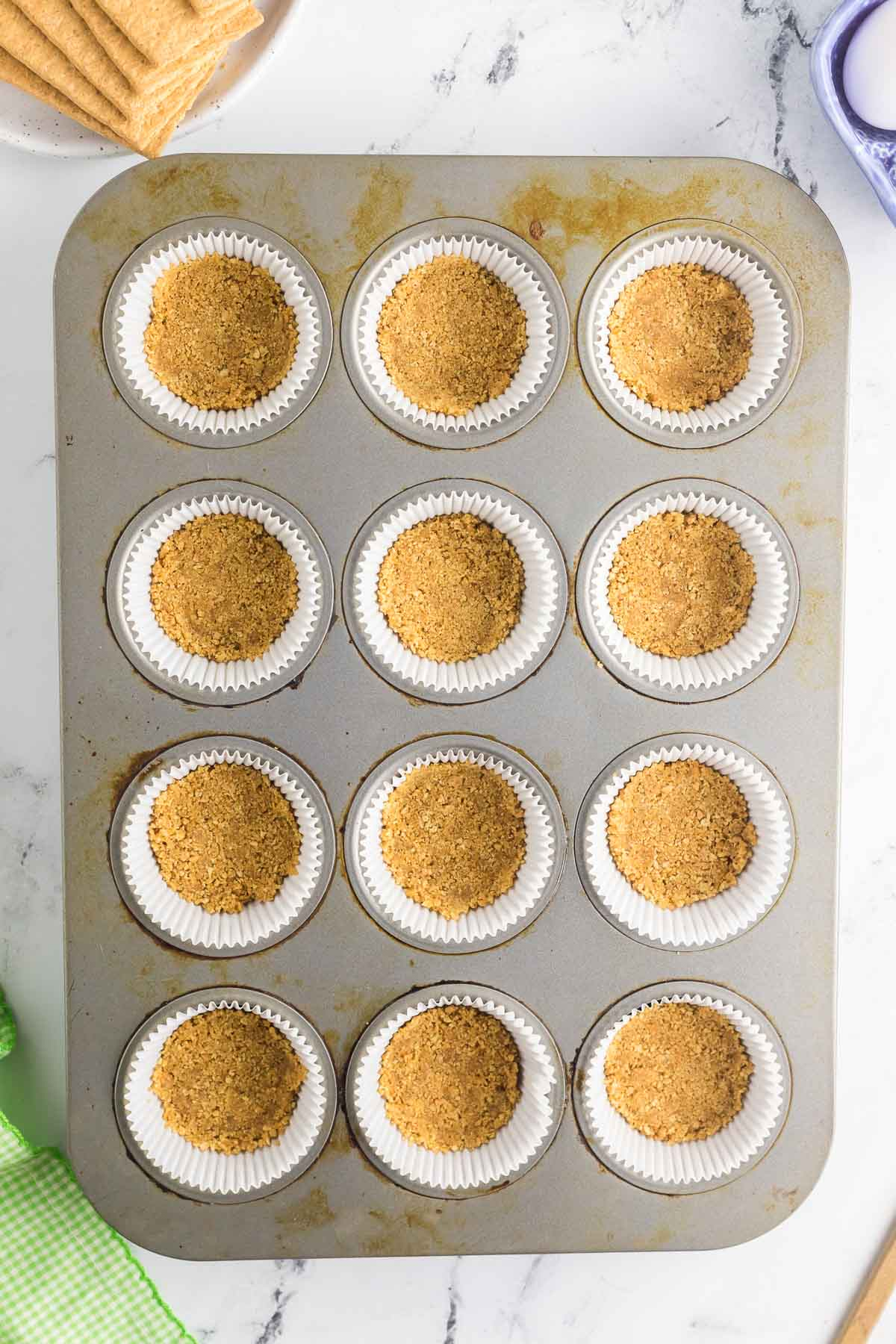graham cracker crust pressed into cupcake liners in muffin tin