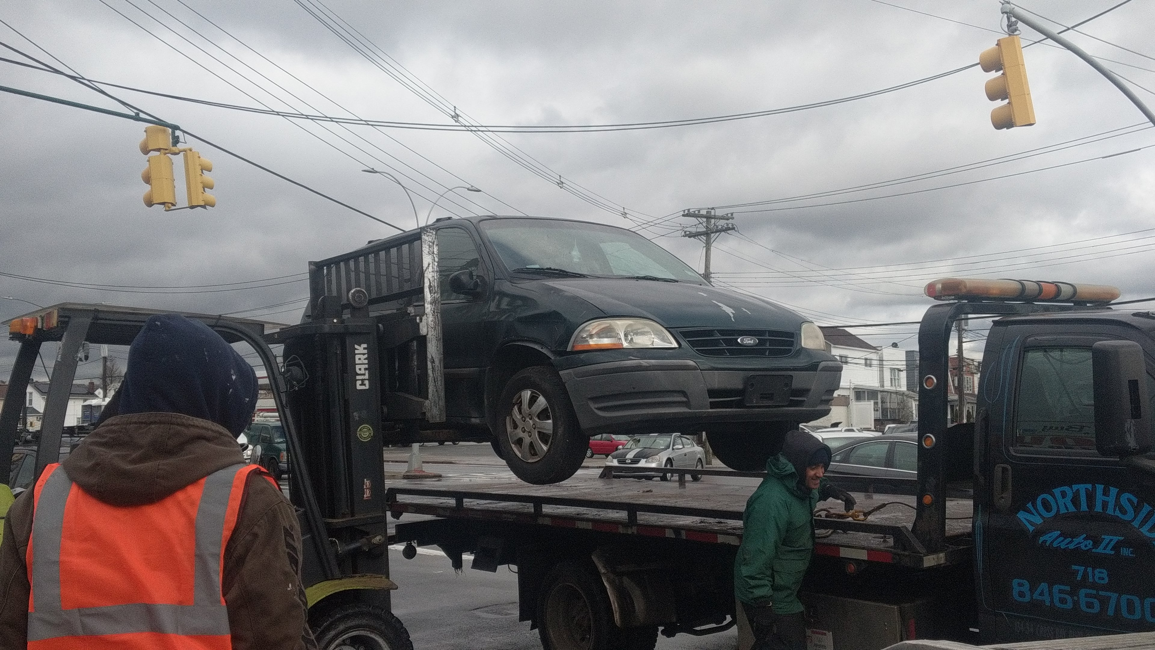 A picture of a tow truck hauling away a scrap car, illustrating junk car removal what is.
