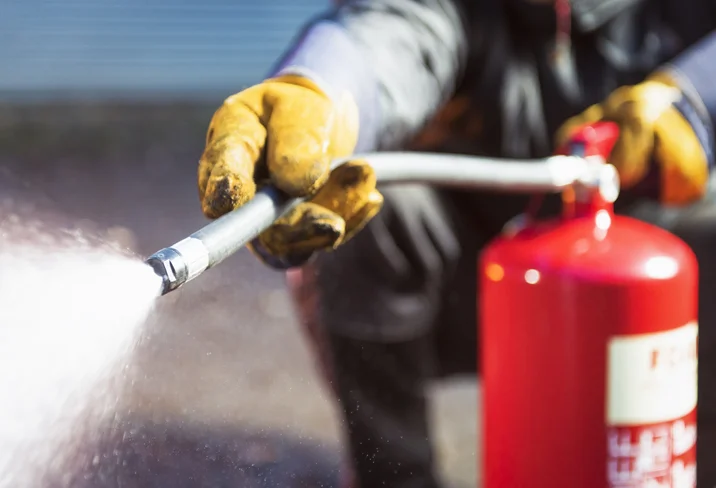 Firefighter using a fire extinguisher