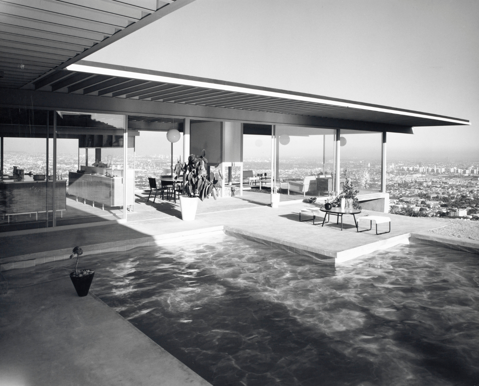 A photograph of the Stahl House pool and outdoor sitting area with views of the Los Angeles basin below.
