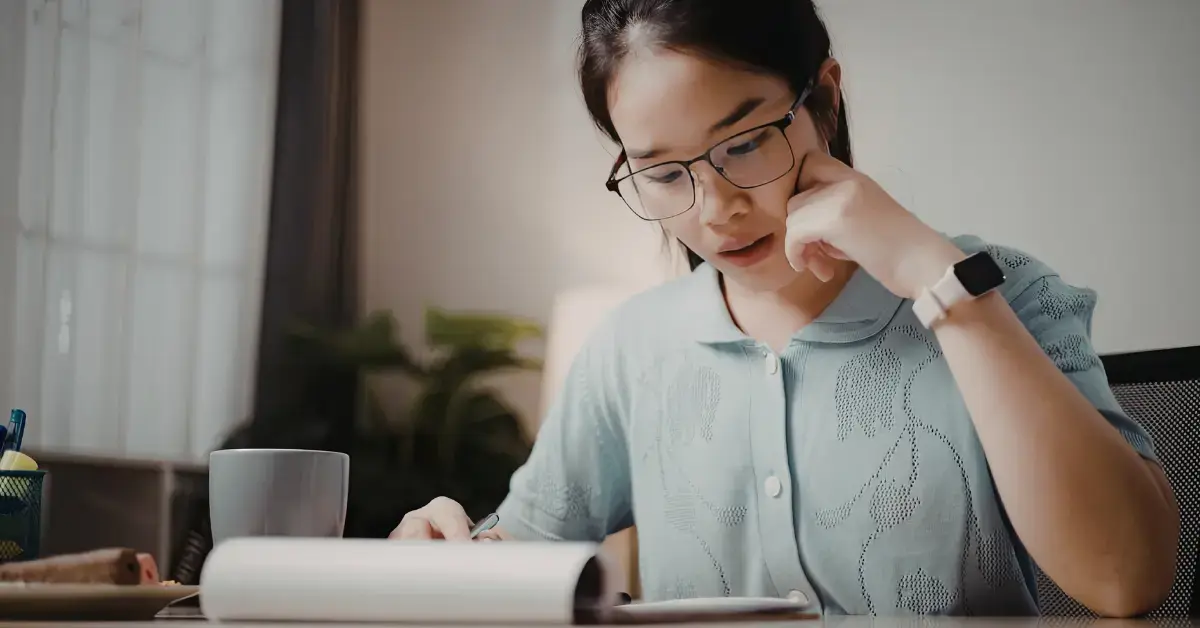Woman reviewing IRS notices and financial records to compare tax lien removal options for unpaid federal taxes.
