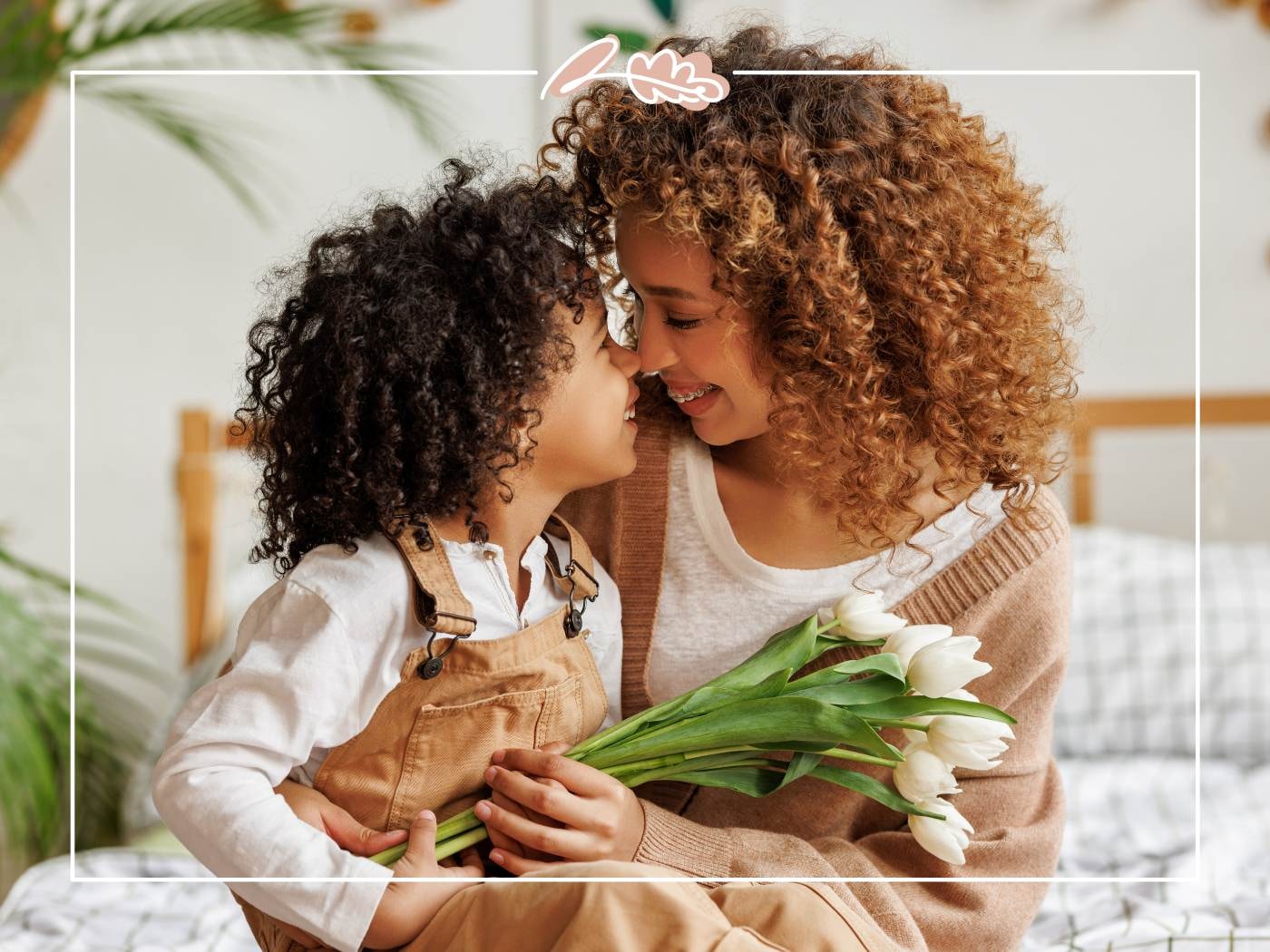 Mum and child sharing a tender moment with a bouquet of tulips.