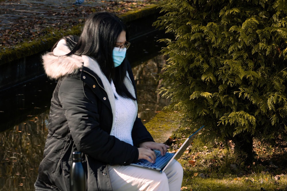A person on the management continuity team sitting, working on a laptop during a power outage staying connected.