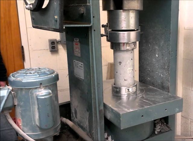 An image of concrete cylinders being tested for strength according to the Best Practices for Concrete Cylinder Testing