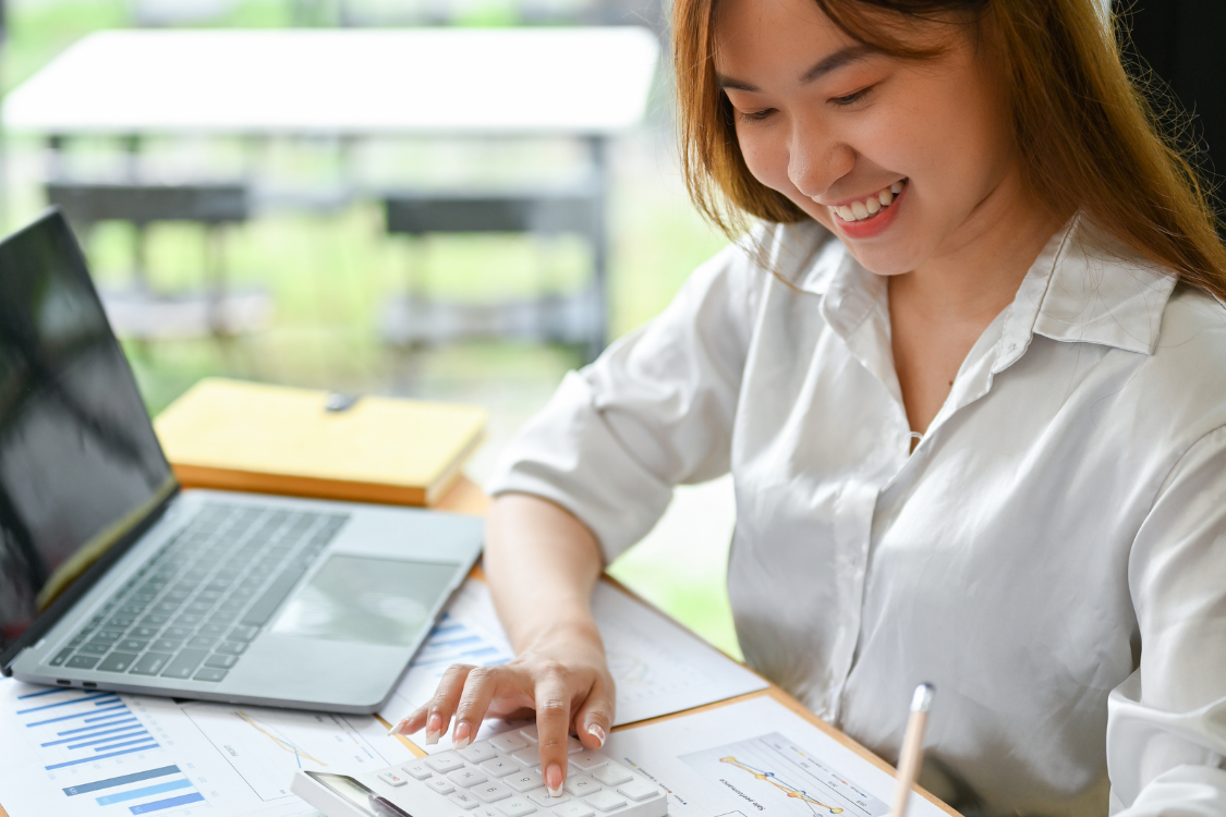 Woman working on a laptop with spreadsheets and charts while doing data entry