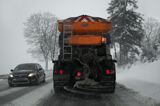 Roadway crews using salt spreaders to apply sodium acetate mixed with beet juice during heavy winter storms.