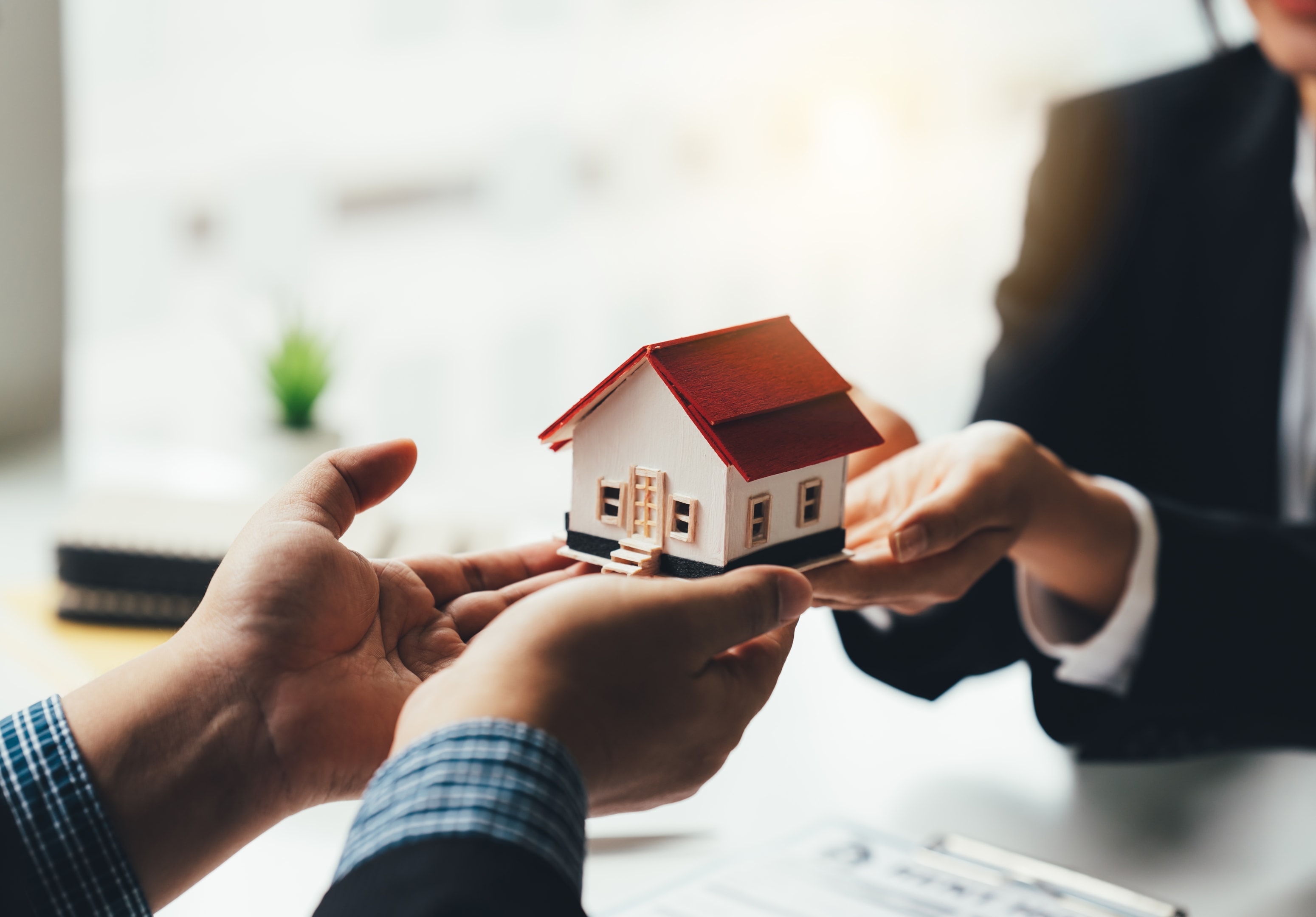 Real Estate Broker Or businessman holding white house model in hand.Mortgage loan approval home loan