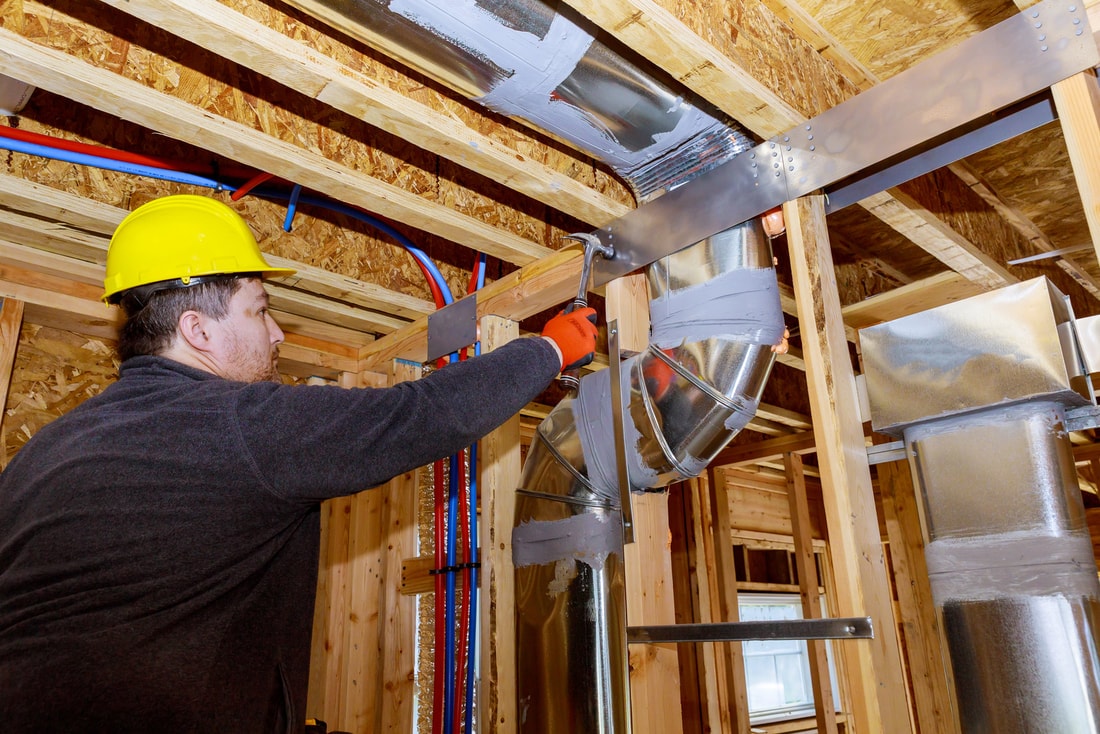 an hvac tech repairing air ducts in phoenix