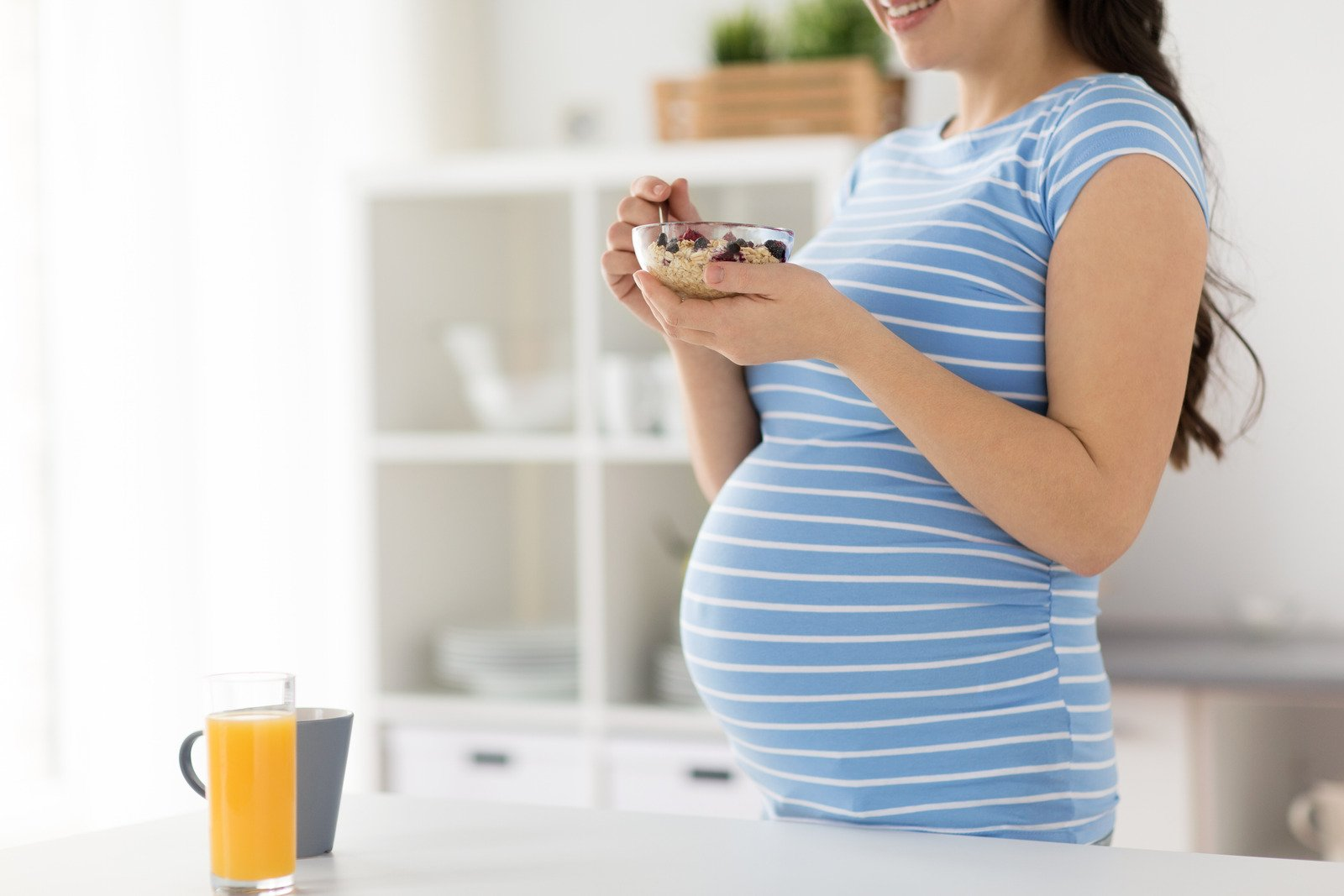 A Pregnancy breakfast being eaten by a woman with a glass of orange juice. 