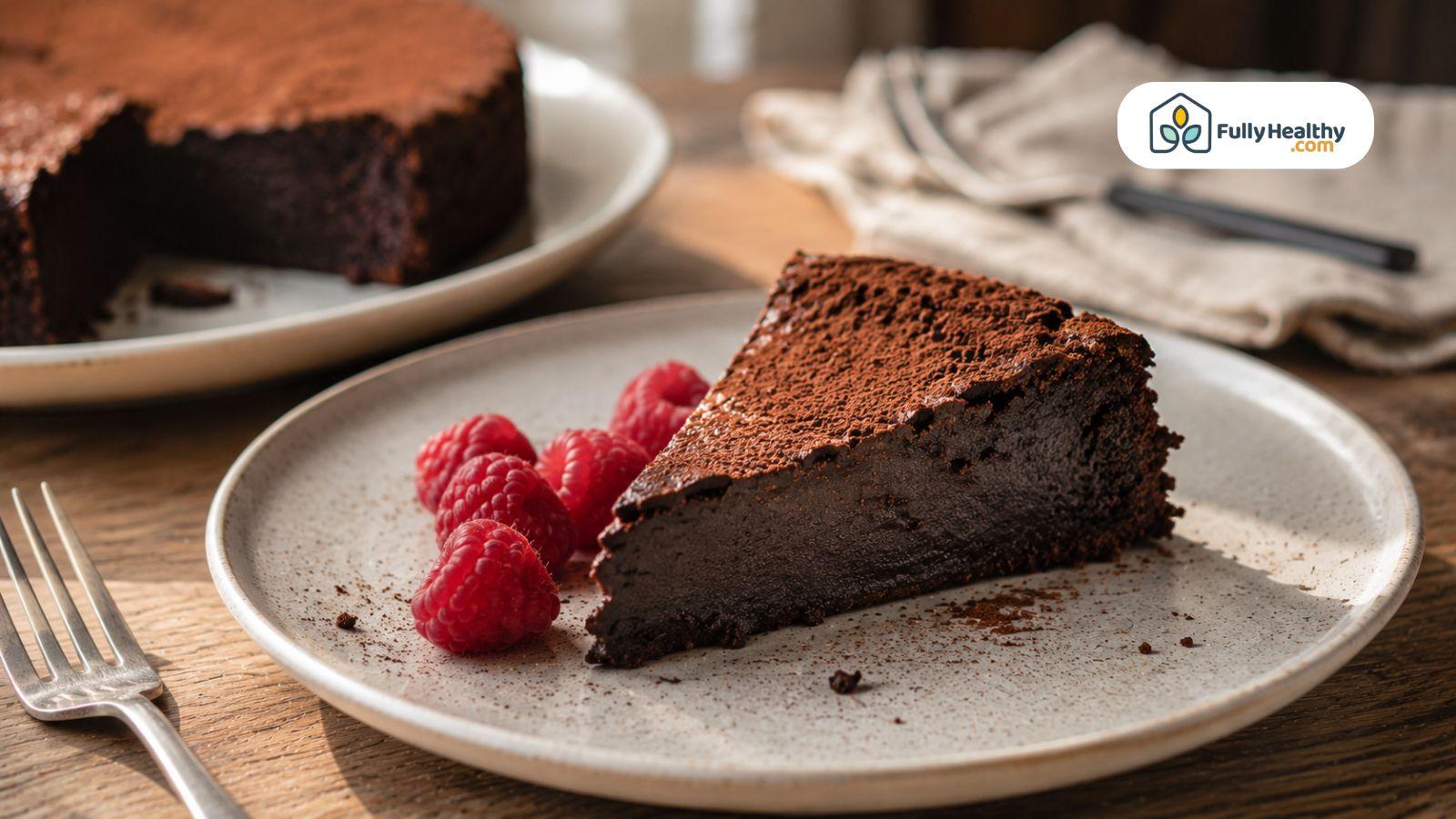 Rich gluten-free chocolate cake slice served with fresh raspberries on plate.