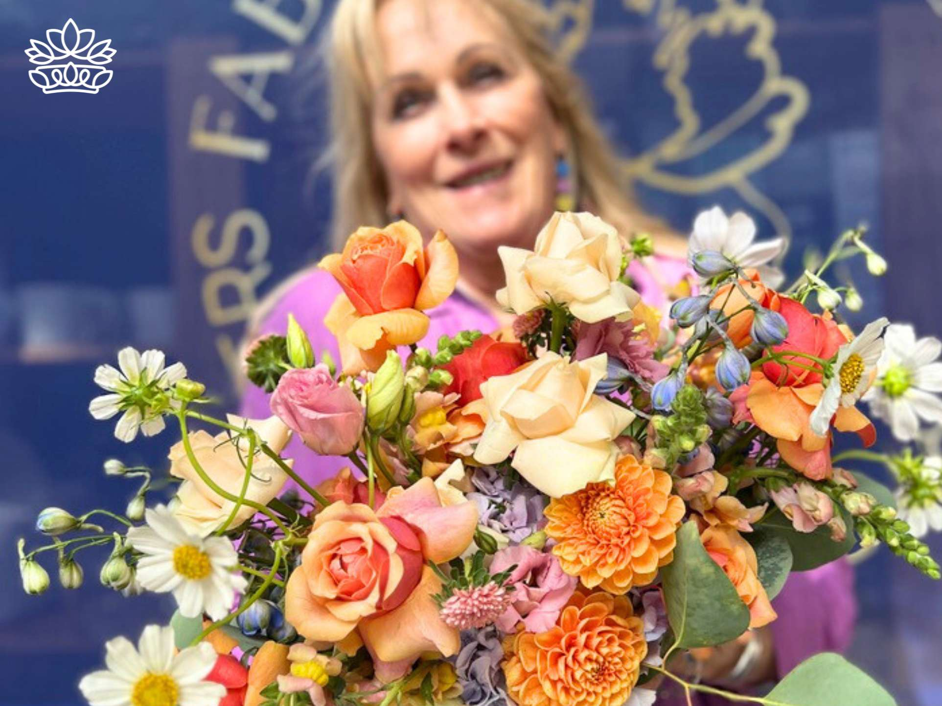 A beaming woman in a vibrant outfit, cradling a lush bouquet of assorted flowers, radiates happiness against the backdrop of Fabulous Flowers and Gifts signage.