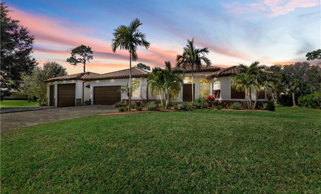 The image showcases luxury waterfront homes nestled along the Caloosahatchee River, adorned with Spanish moss-covered oak trees, creating a serene and picturesque setting in North Fort Myers. This scene highlights the appealing lifestyle and community available for prospective property consumers interested in real estate in the area.