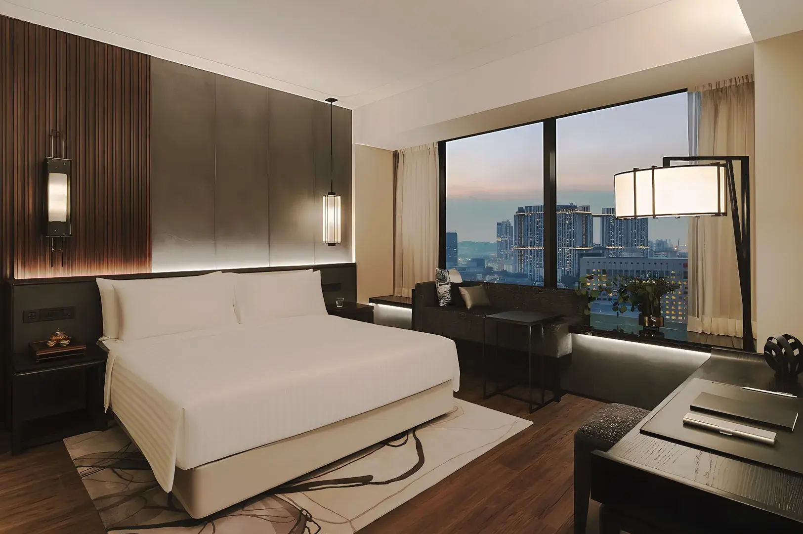 Luxury Singapore hotel room with king bed, warm lighting, and panoramic city view at dusk