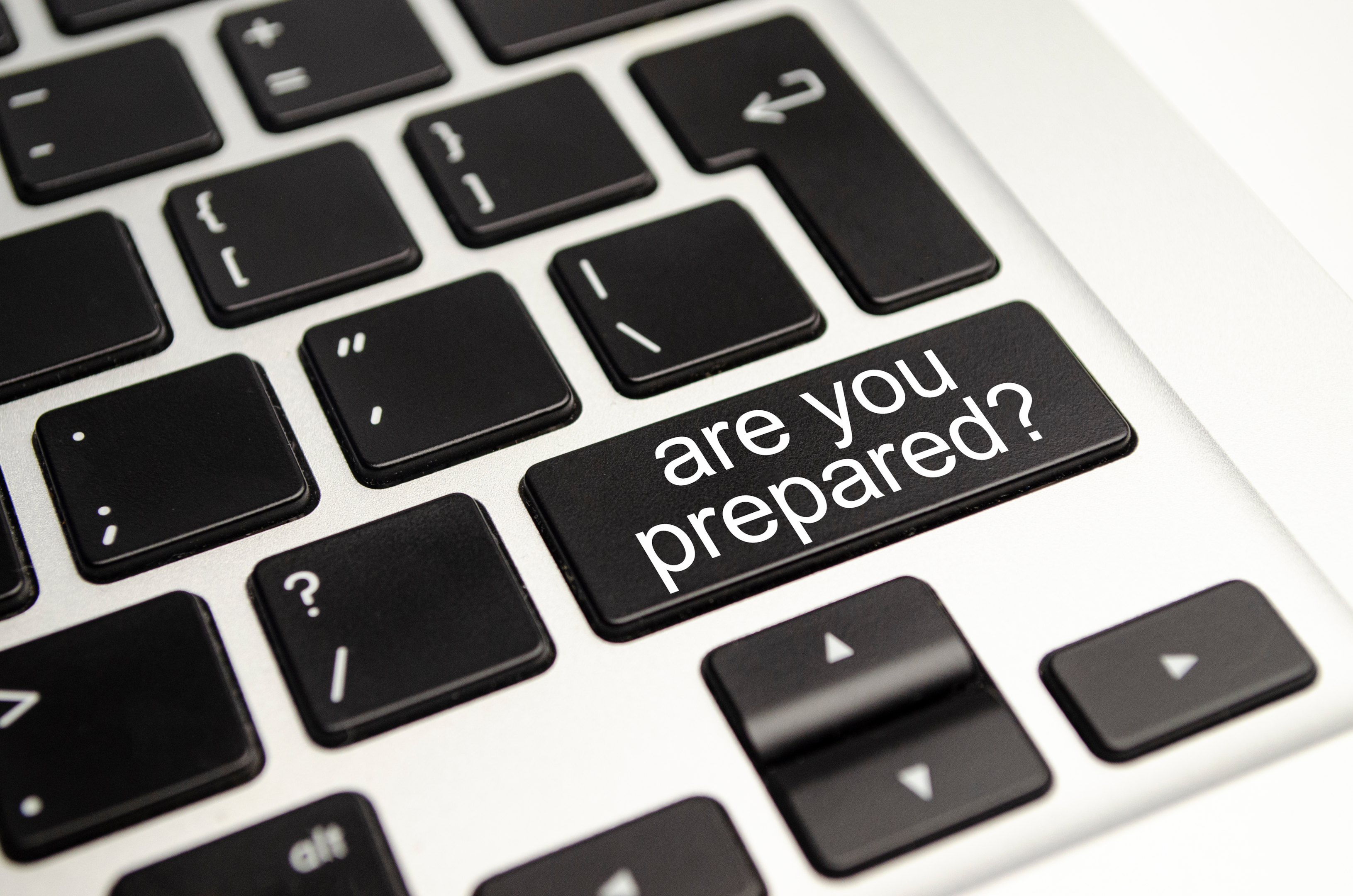 black keys on silver laptop; one key reads "are you prepared?"