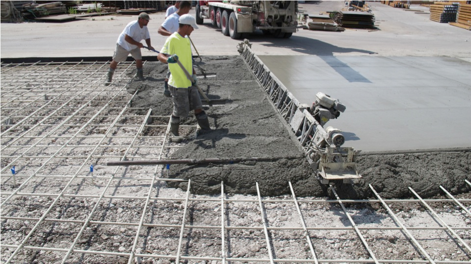 Photo of workers installing screed chairs on a construction site