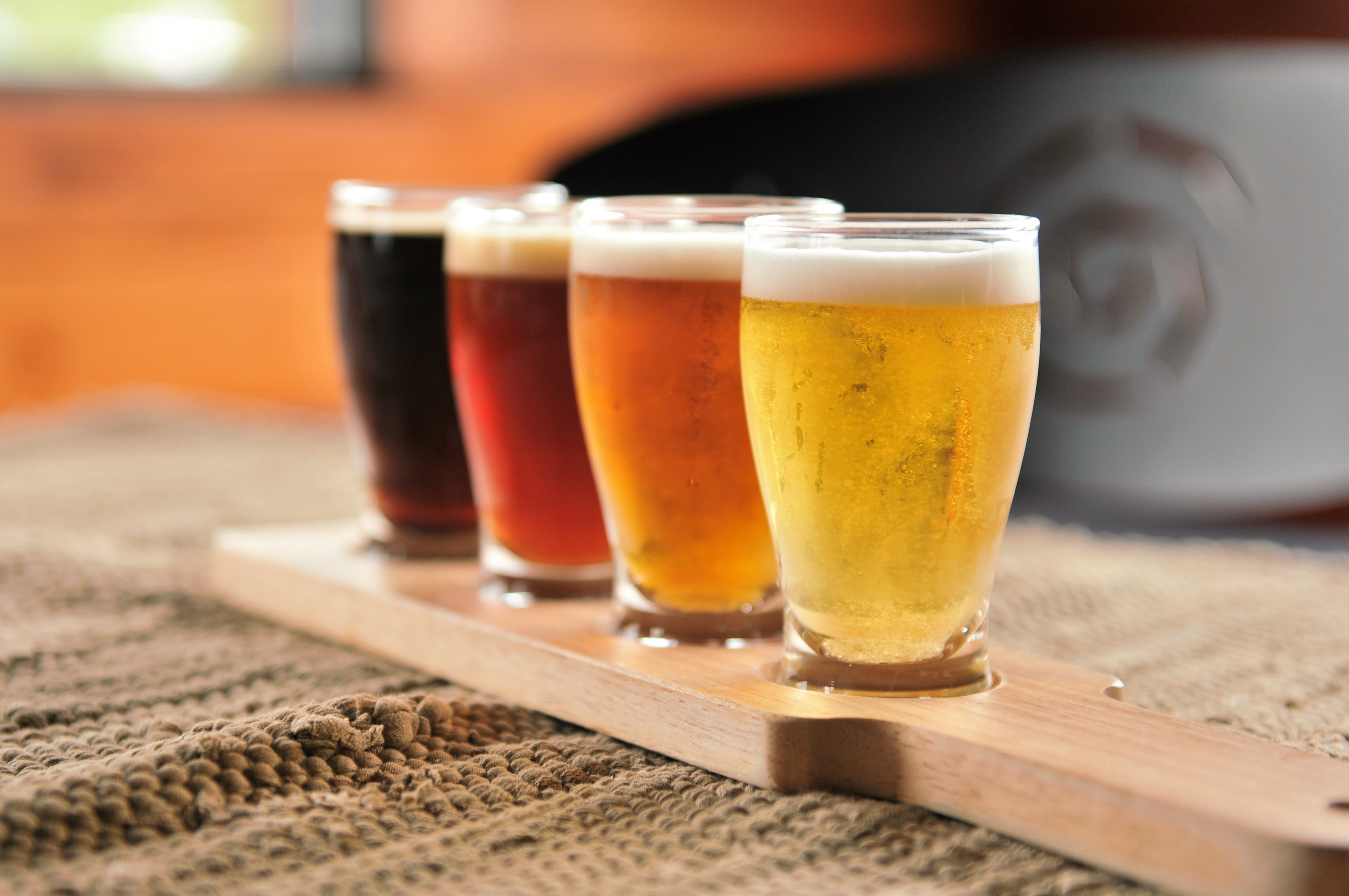small beer flight of multicolored beers on a wooden flight board 