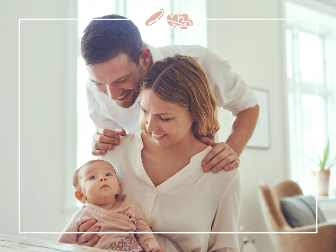 A couple adoring their baby, sitting together in a bright and airy room. Fabulous Flowers and Gifts.