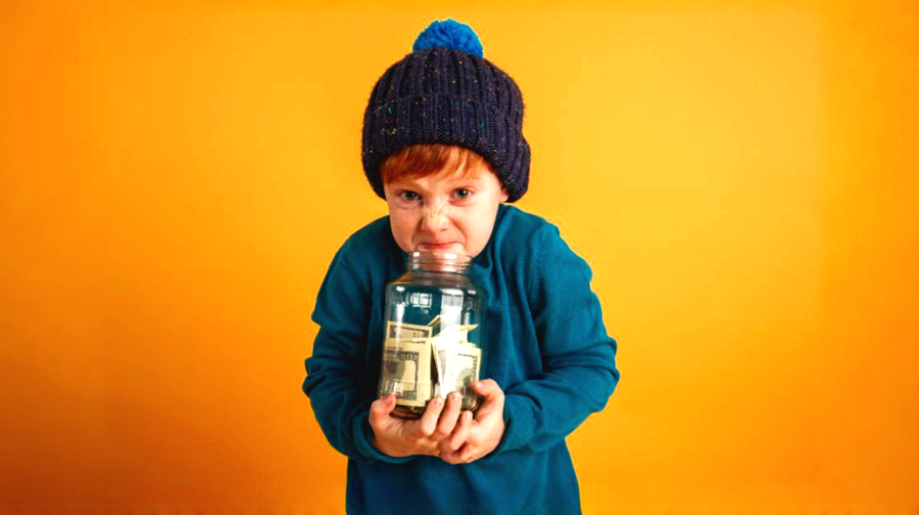 Angry child holding jar of money. Conveys not wanting to pay a lot for telecom website design or other marketing services.