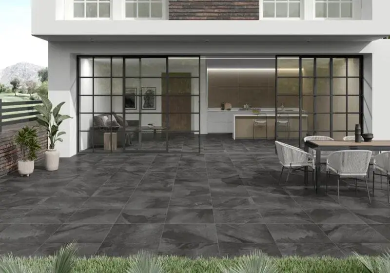 Rhin Grafito 20mm Outdoor Porcelain Tiles (90×60cm) work beautifully alongside grass, creating a striking contrast that enhances both the patio and surrounding greenery.