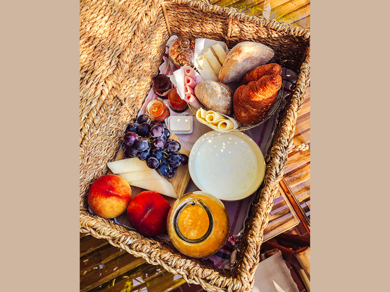 Cesta de café da manhã com pães, frios e frutas. Foto: muunique via Getty Images - Canva
