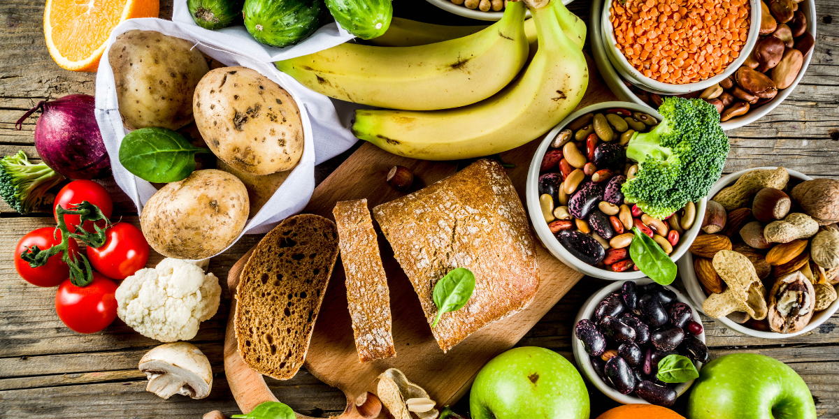 A table full of carb-rich foods such as potatoes, bread, and beans. Reverse dieting can be a great opportunity to eat more carbs while achieving body composition goals.