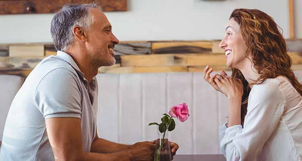 A man and a woman smiling at each other in a restaurant https://www.bonobology.com/signs-guy-loves-secretly/