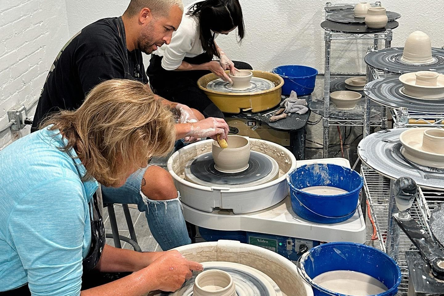 A corporate team using potter's wheels at Community Clay 
