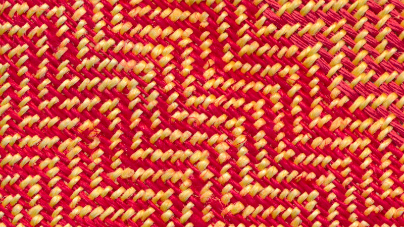 A close up image of a red and yellow twill fabric