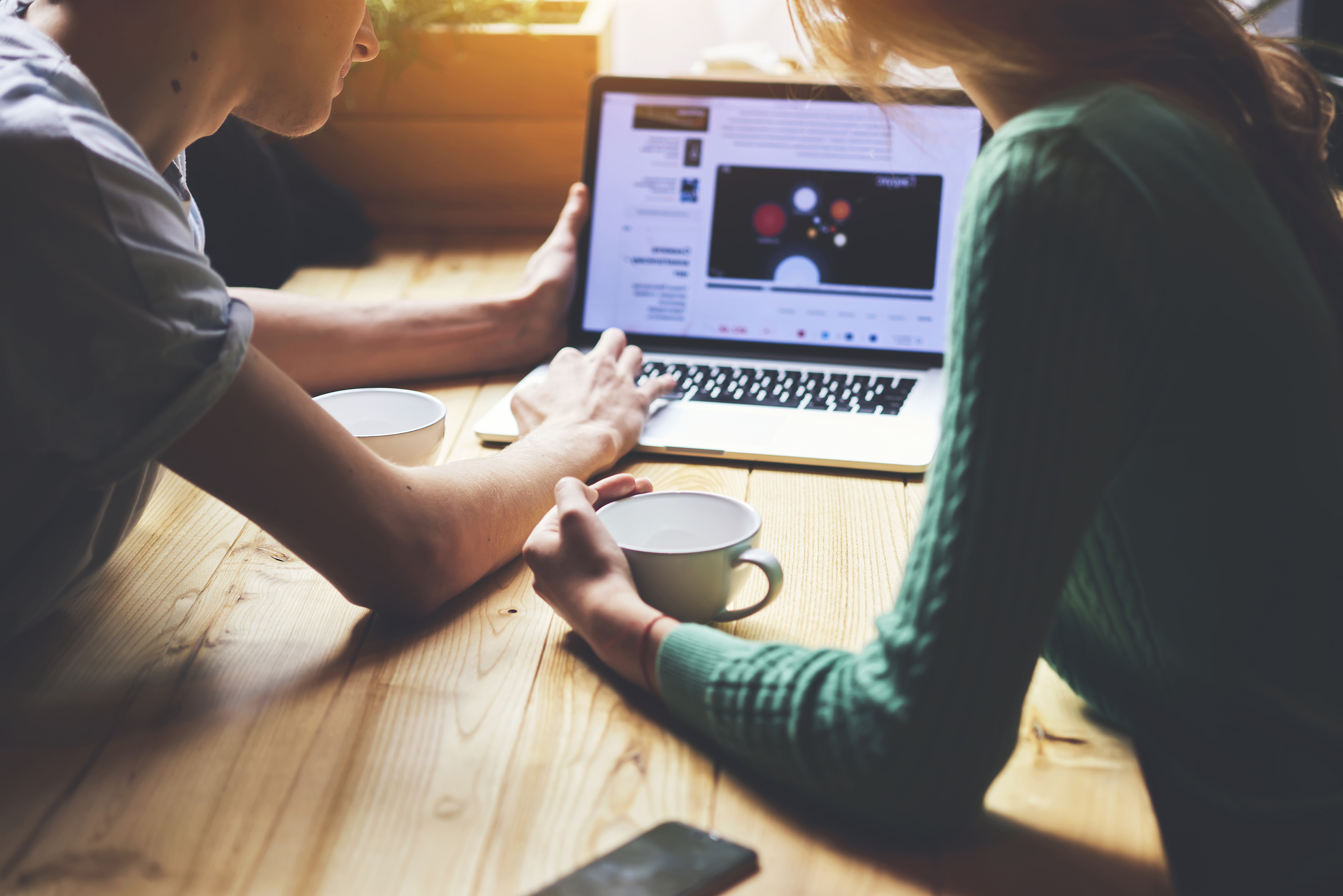 two people browsing the open internet on a laptop