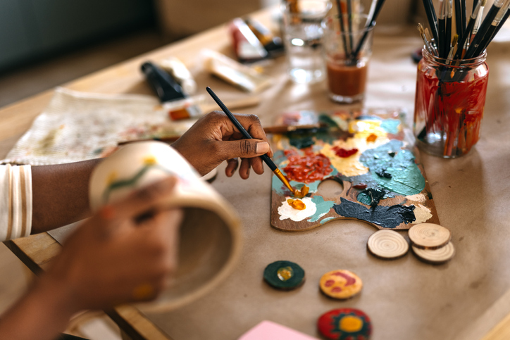 Woman painting a flowerpot.