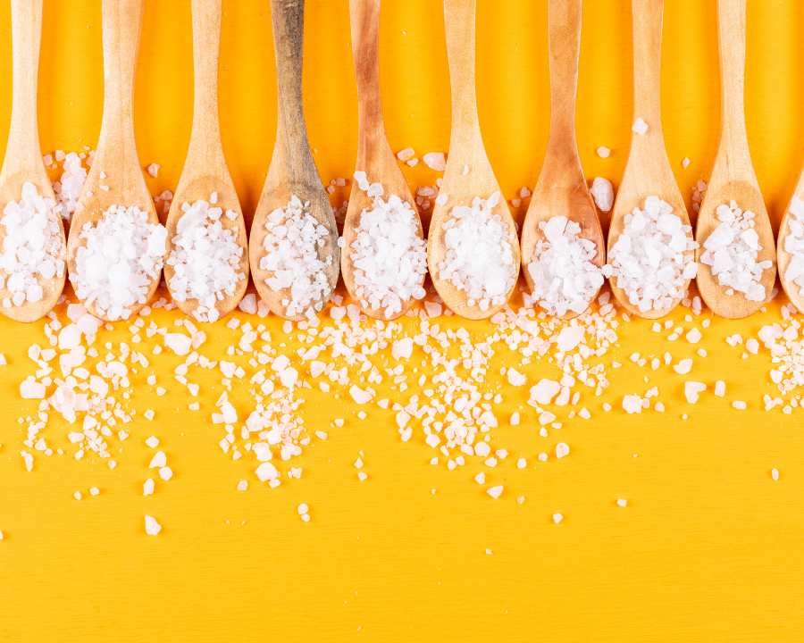 MSM (Methylsulfonylmethane): A Guide to Benefits, Dosage, and Safe Usage – row of spoons with scattered MSM flakes.