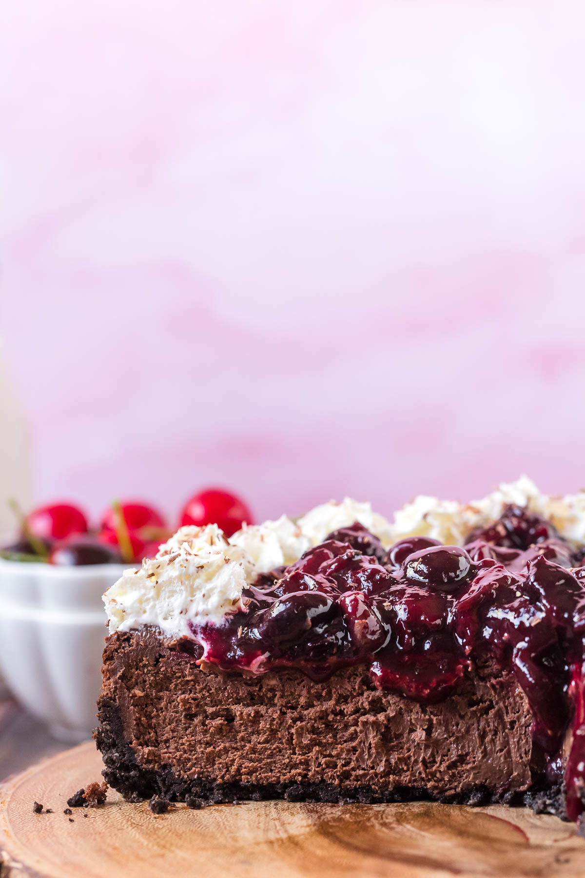 cut away view of black forest cheesecake topped with whipped cream 