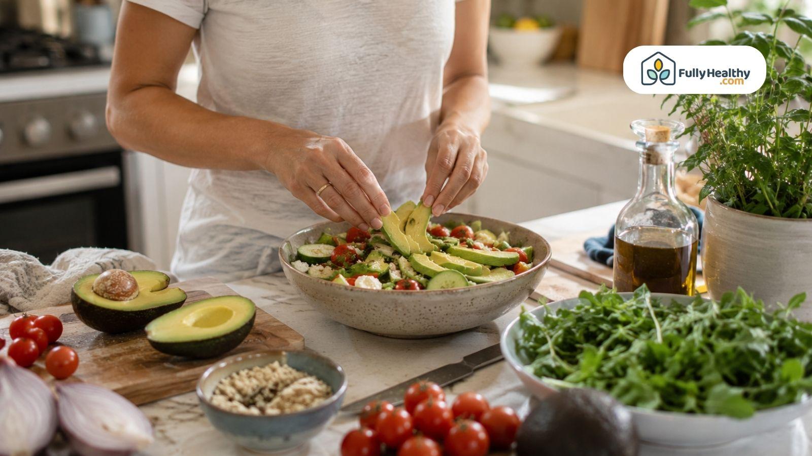 Woman preparing fresh avocado salad in a bright modern kitchen.