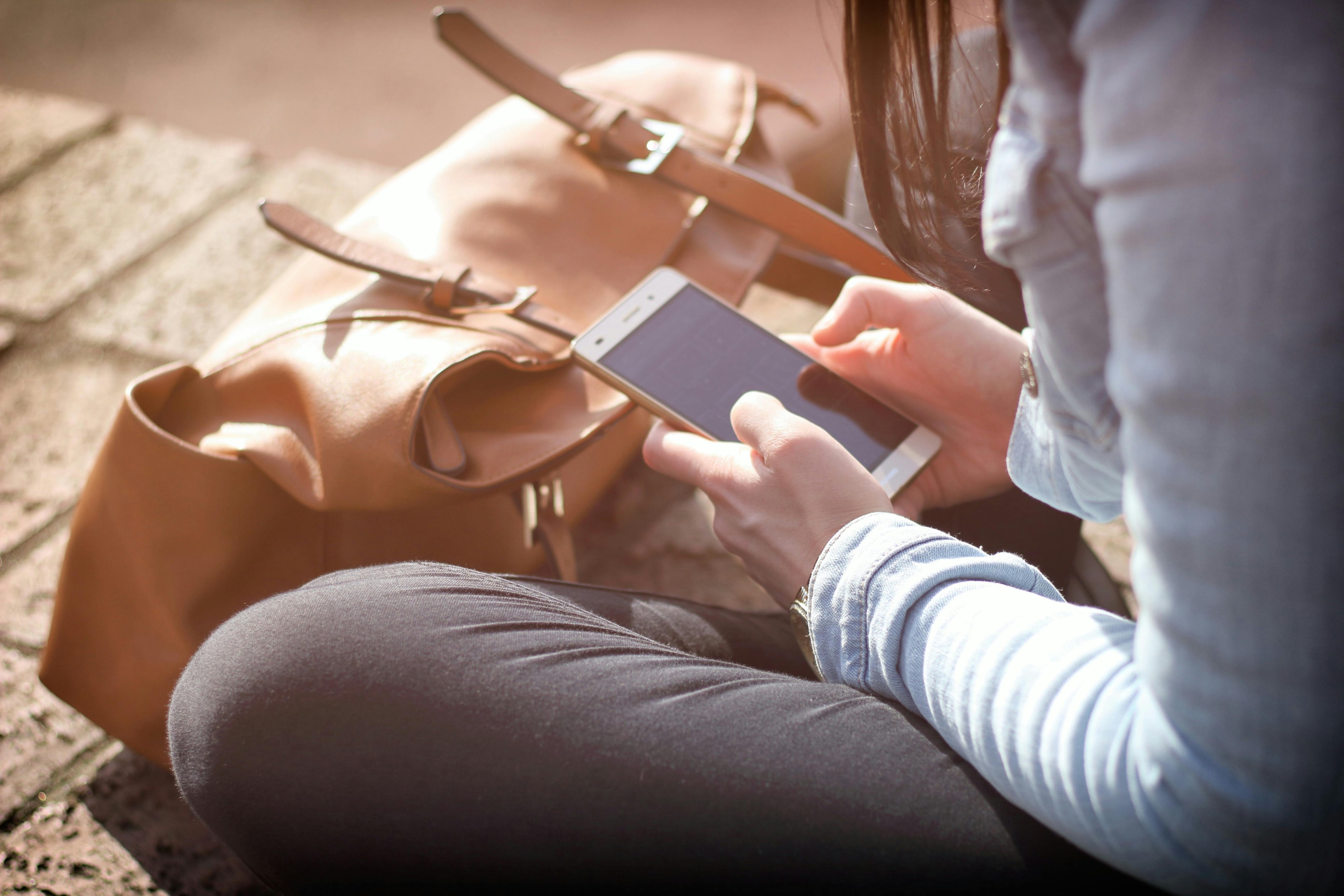 Woman searches the web on her phone for help selling her home. 