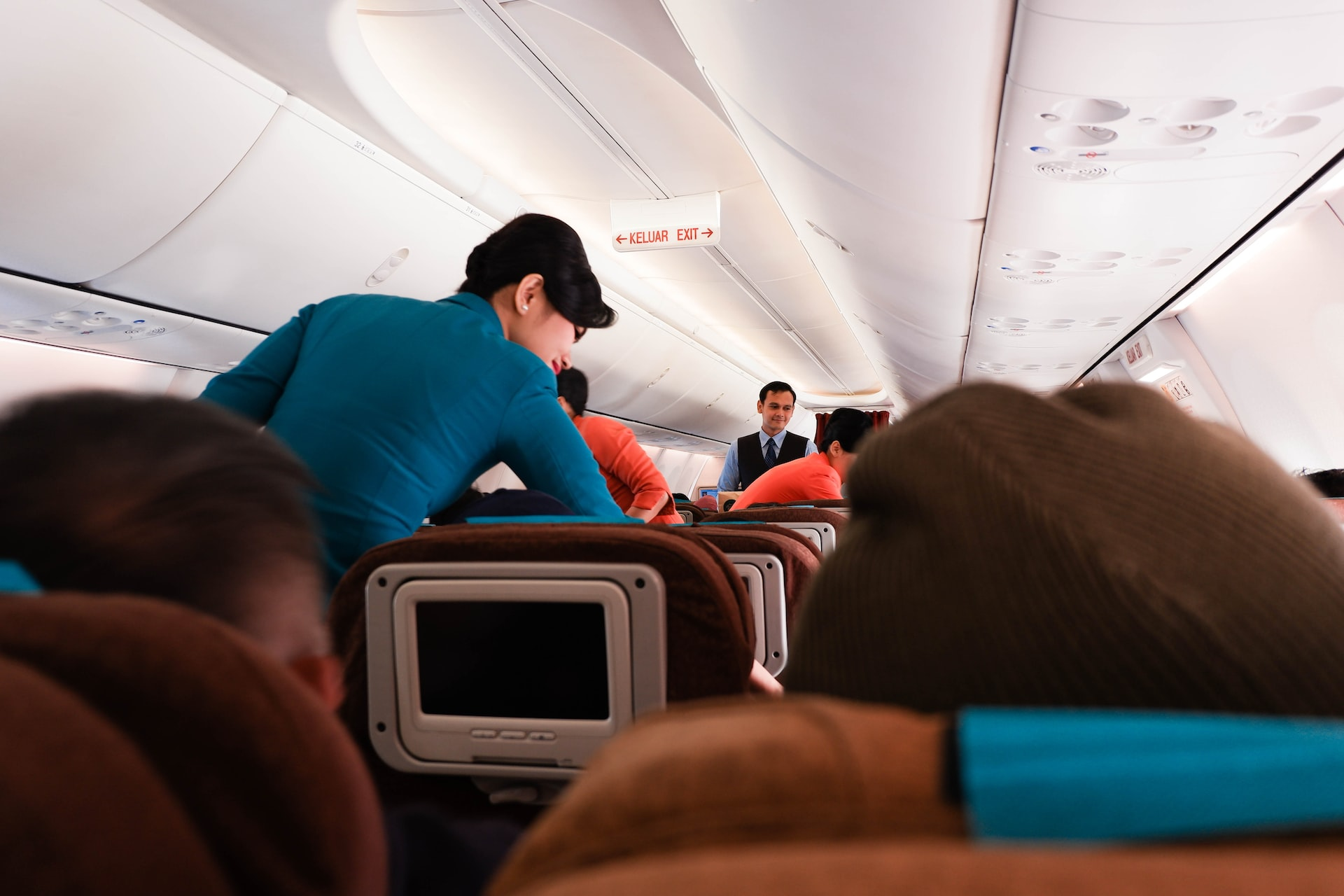 Flight attendant during a cruising flight phase serving passengers on board.