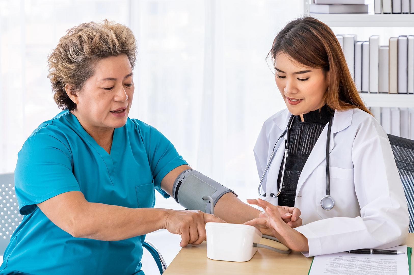 Doctor checking a patient’s blood pressure during a medical exam.
