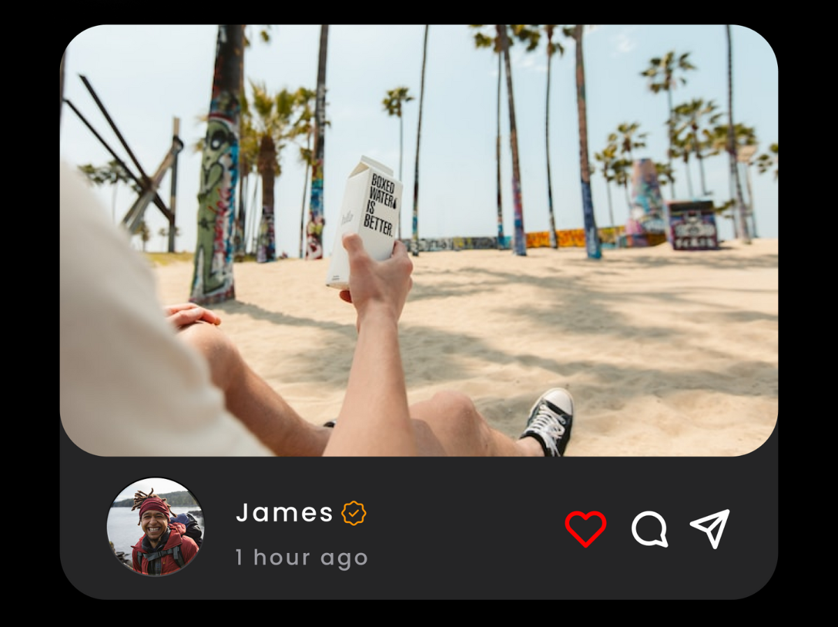 Picture from a beach of a man sitting with a drink in carton in hand