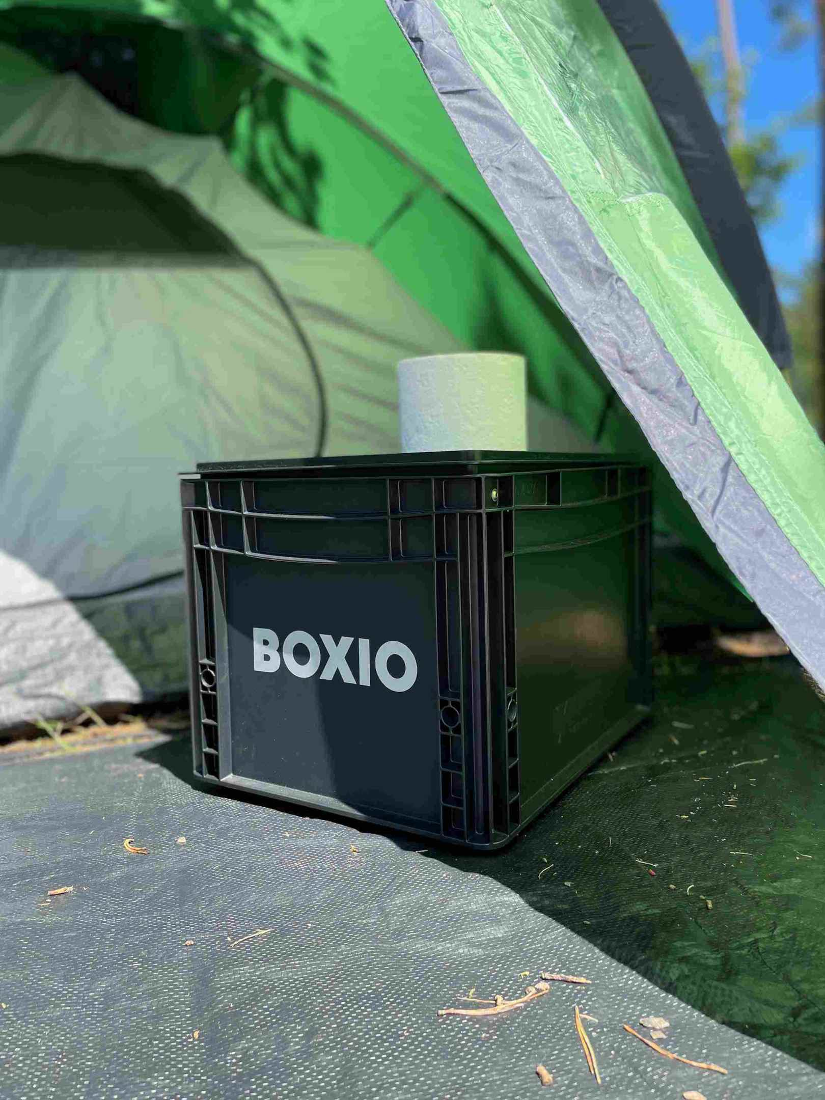 BOXIO-TOILET steht im Zelt, auf der Trenntoilette steht eine Rolle Toilettenpapier