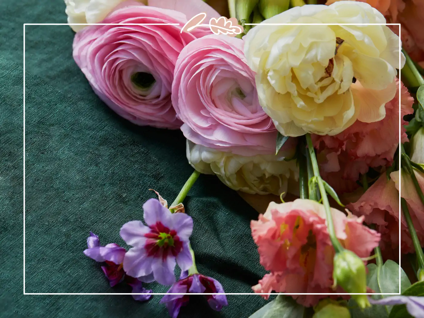 Close-up of pink, yellow, and peach flowers arranged on a green surface. Fabulous Flowers and Gifts