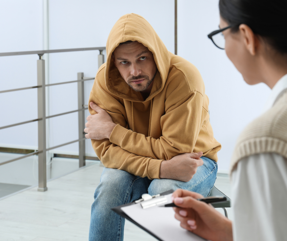 A person in recovery from alcohol addiction standing in front of a rehab center