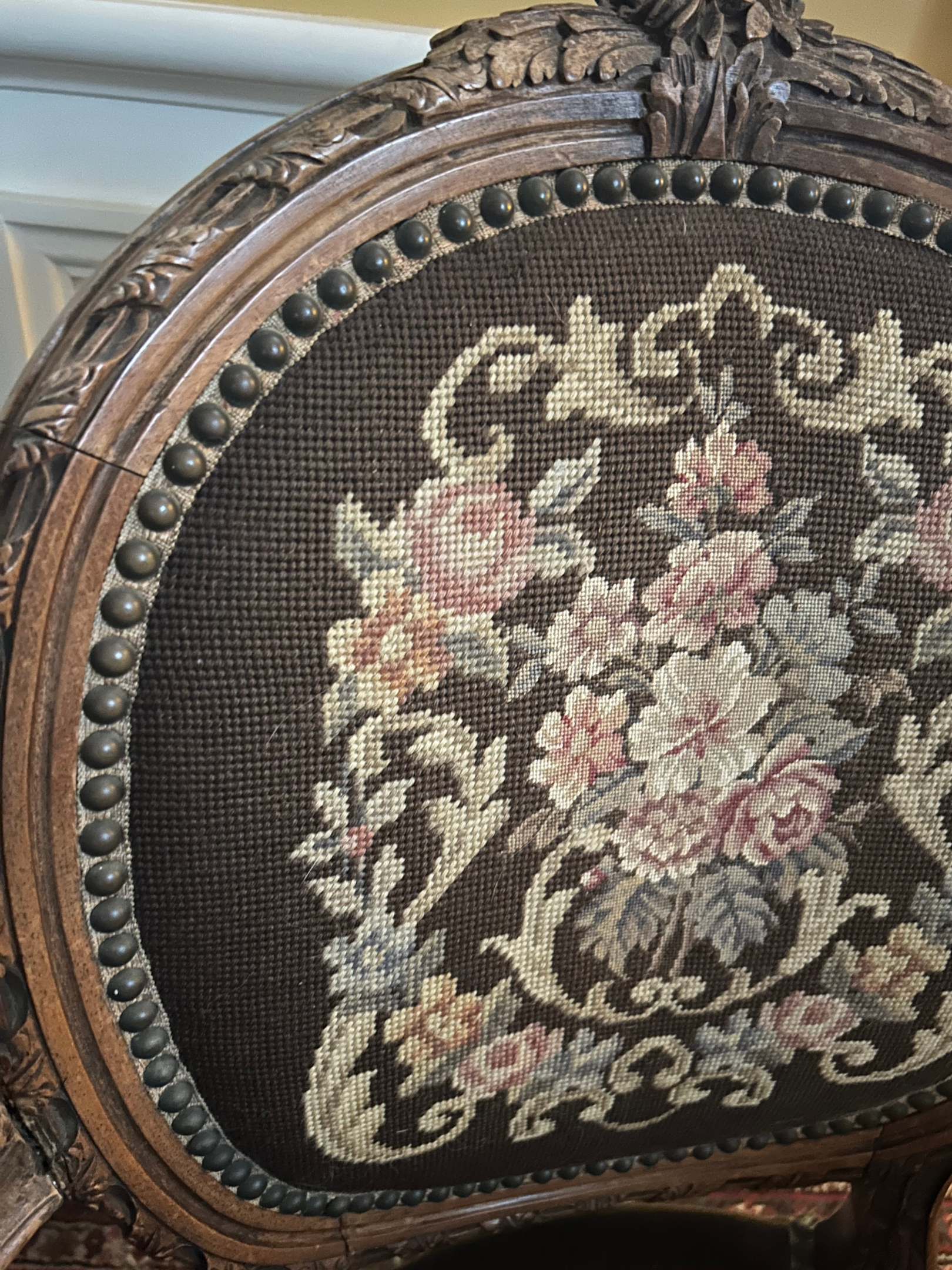 Nail head trim on an antique needlepointed chair