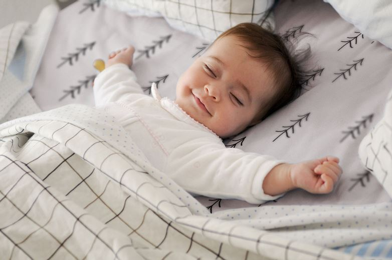 baby smiling as they are sleeping