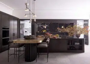 high end kitchen with a dark color palette and tall dining table