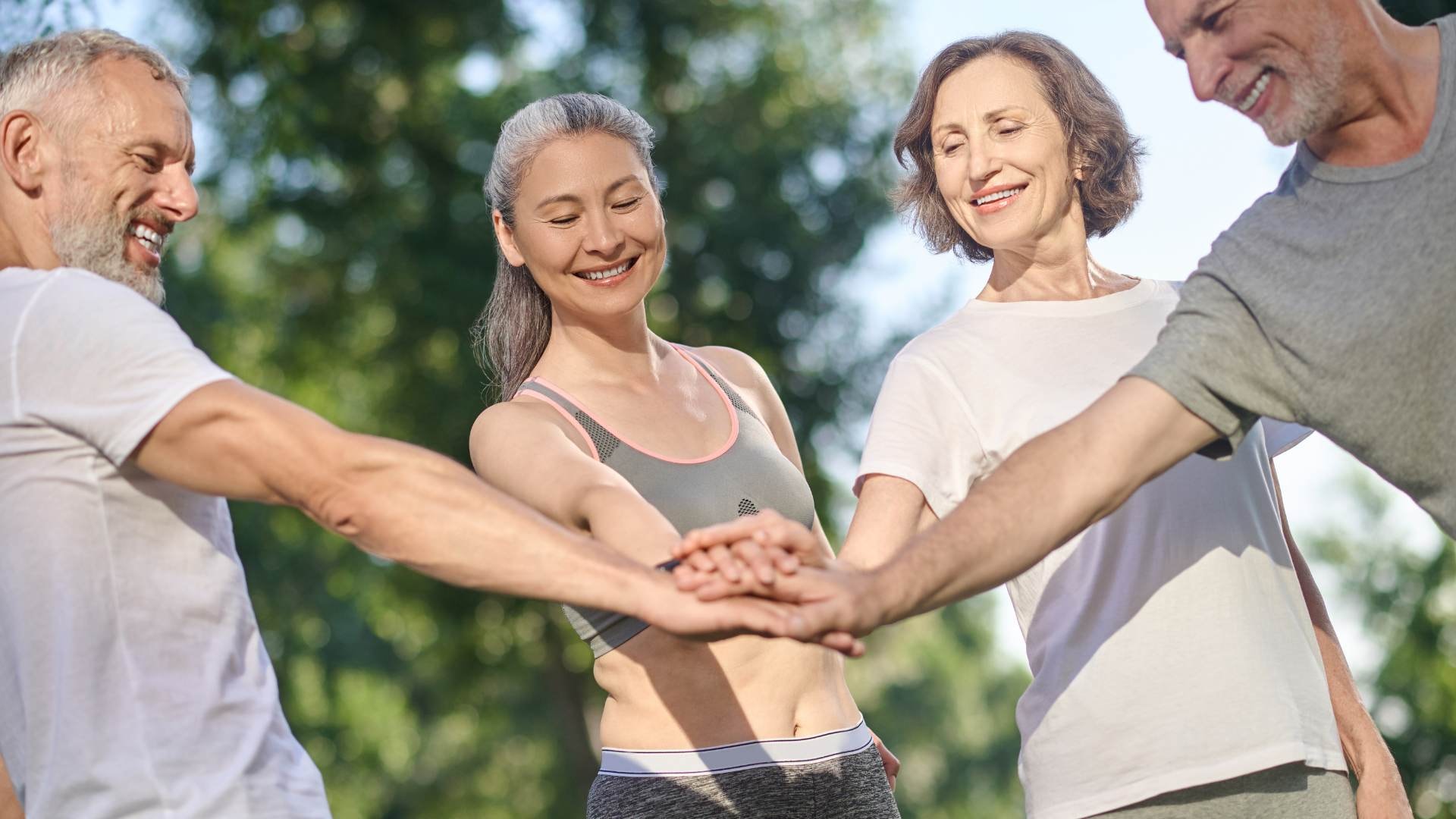 Group stacking hands outdoors, showing unity in liver health, fatty liver disease prevention, and support for healthy liver function.