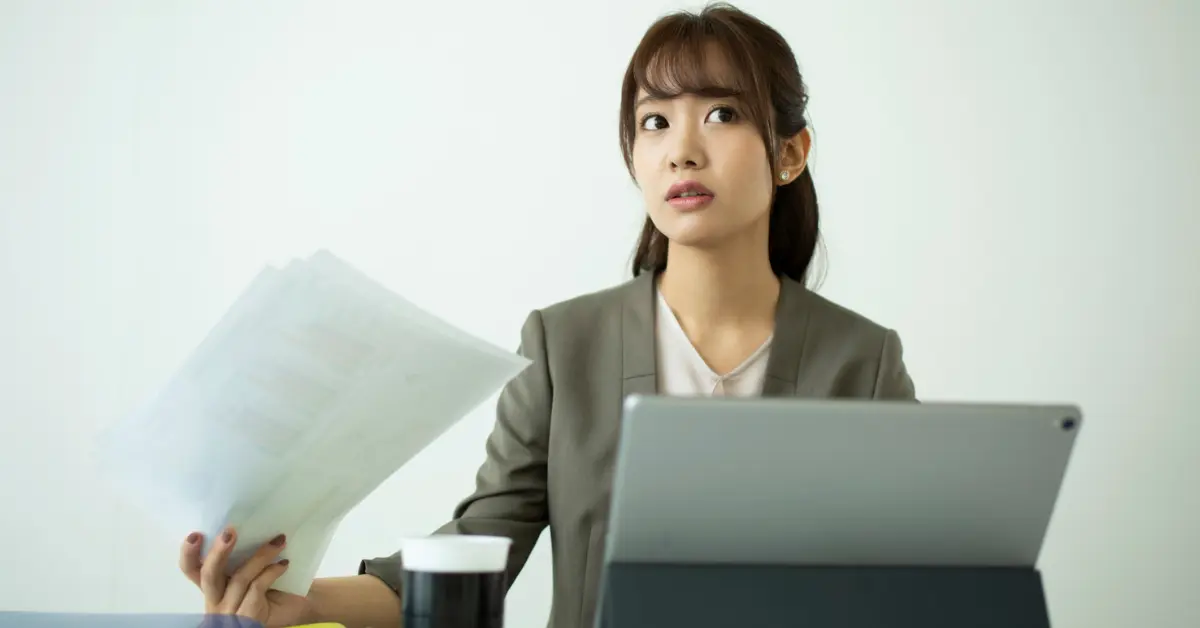 Woman reviewing business paperwork while deciding can you change the name of your LLC.