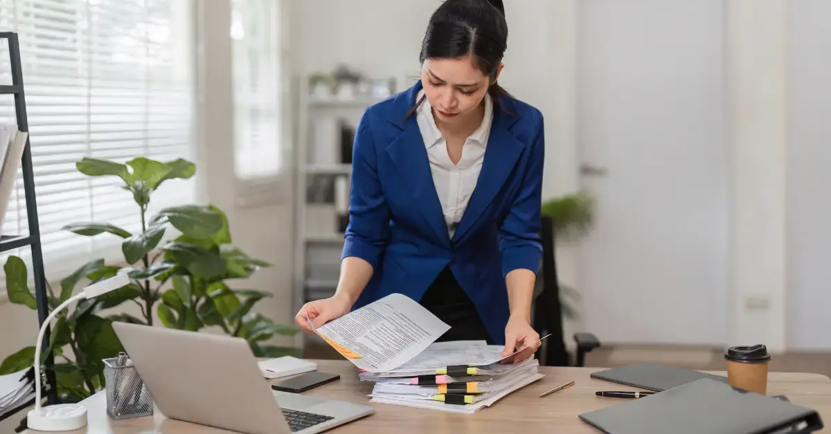 Woman reviewing tax paperwork and quarterly payments while following Form 2210 instructions.
