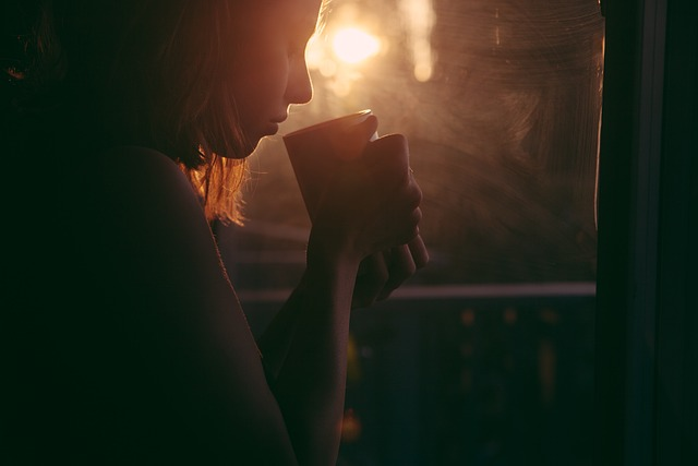 An image of a young girl drinking a cup of tea to hydrate her throat.