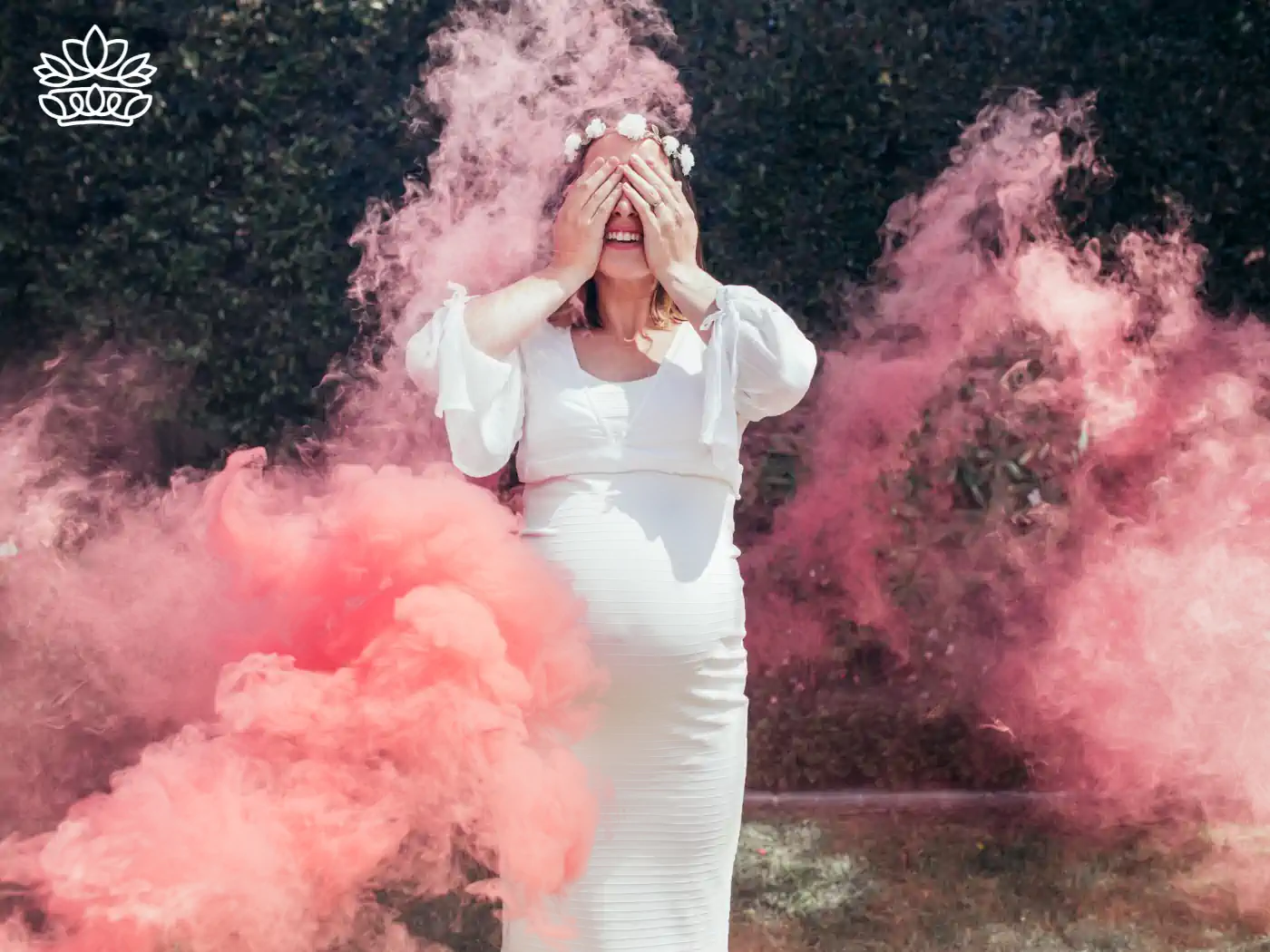 Pregnant woman in white dress with pink smoke in a gender reveal party - Fabulous Flowers and Gifts.