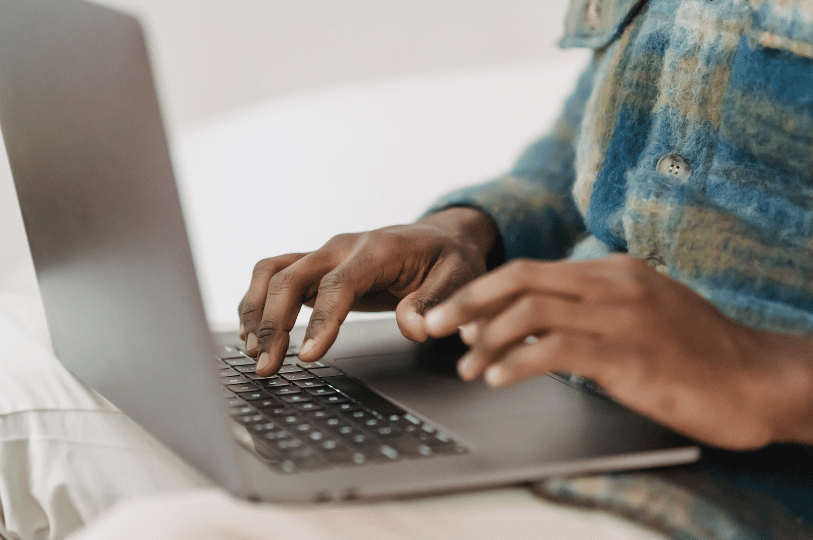A close-up side view of a person’s hands typing on a laptop keyboard, emphasizing the process of executing digital marketing or SEO tasks.