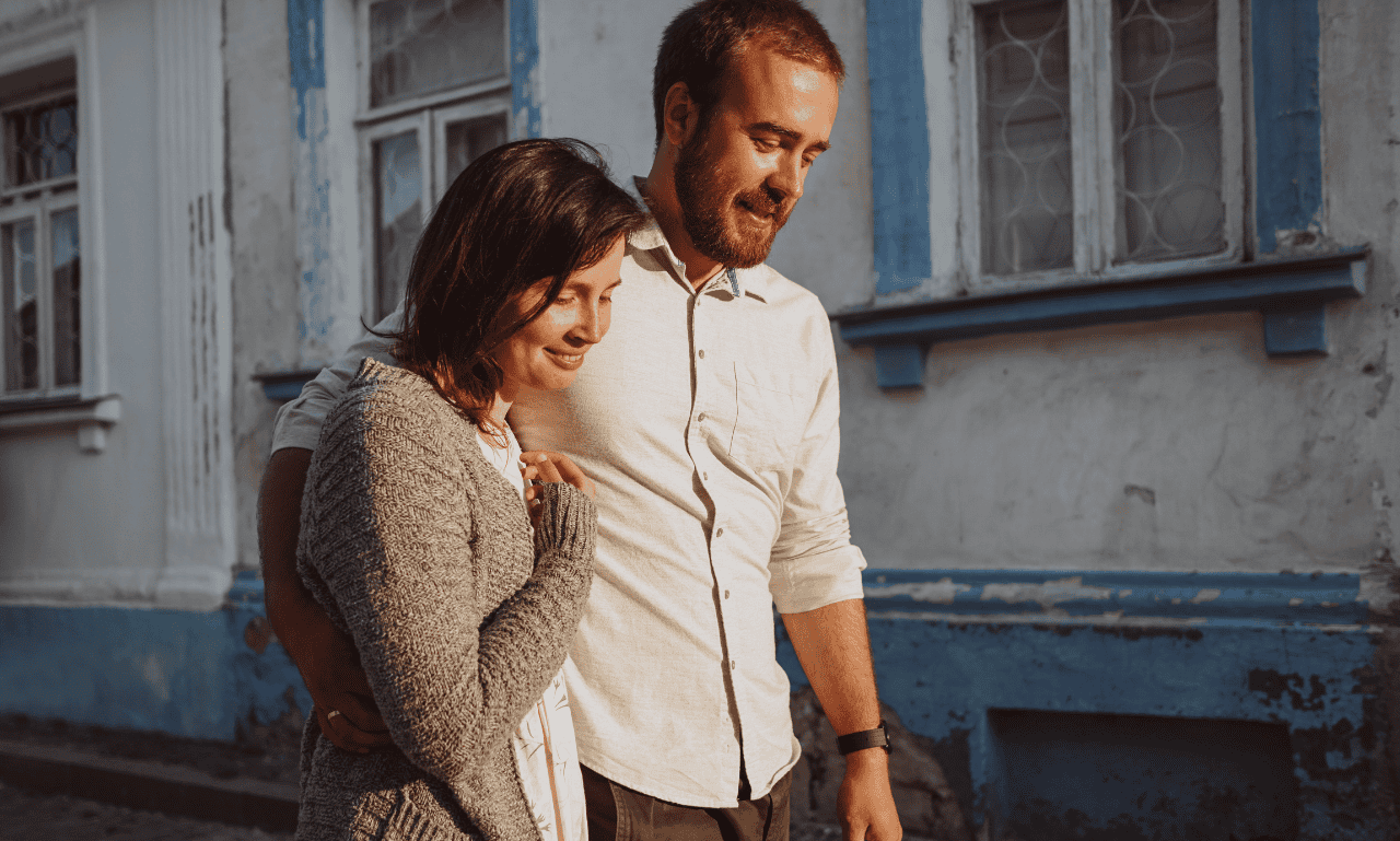 A couple walking in the street moments before they lock lips.